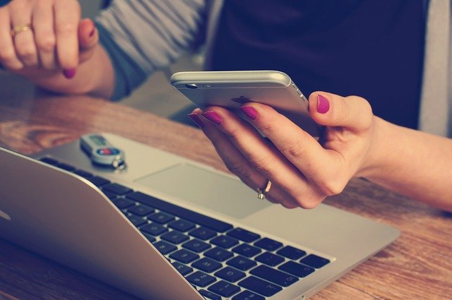 multitaskaamista: puhelin ja tietokone käytössä yhtaikaa
